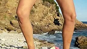 She walks naked on the public beach, inserting pebbles into her pussy.
